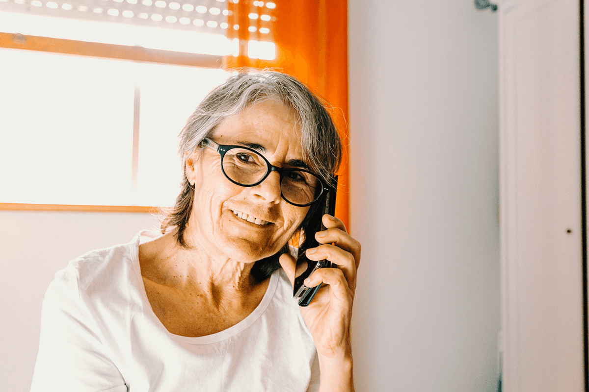 Woman wearing glasses talking on the phone at home